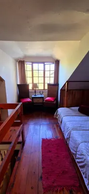 a bedroom with a bed and two chairs and a table at Mountain Haven Kaapsehoop in Kaapsehoop