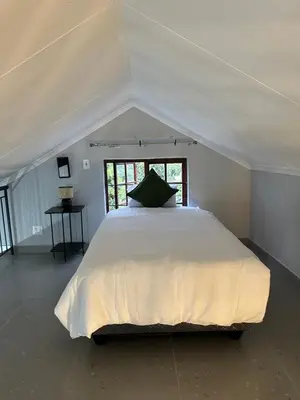 a bedroom with a large white bed in a tent at Pendleberry Grove 33 in Bela-Bela