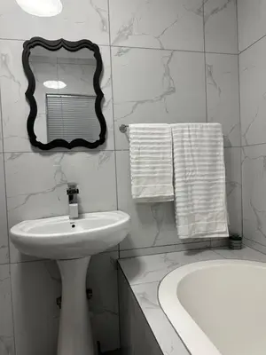 a white bathroom with a sink and a mirror at Pendleberry Grove 33 in Bela-Bela