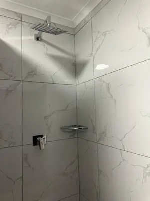 a bathroom with a shower with marble walls at Pendleberry Grove 33 in Bela-Bela