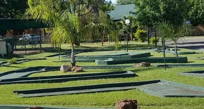 a park with palm trees and rocks in the grass at Pendleberry Grove 33 in Bela-Bela