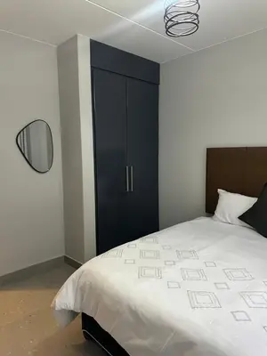 a bedroom with a large bed and a black cabinet at Pendleberry Grove 33 in Bela-Bela