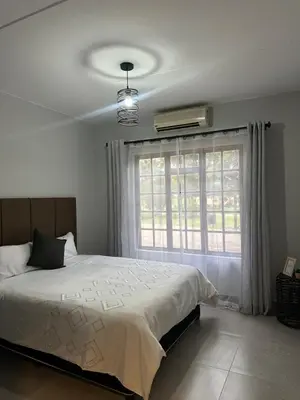 a bedroom with a large bed and a window at Pendleberry Grove 90 in Bela-Bela