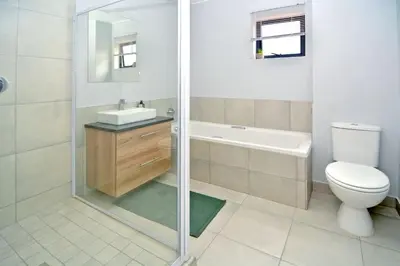 a bathroom with a shower and a toilet and a sink at Safubi 2 bedroom apartment in Nelspruit