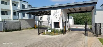 an empty parking lot with a gate in front of a building at Safubi 2 bedroom apartment in Nelspruit