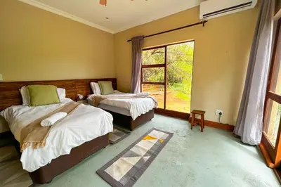 a bedroom with two beds and a window at Elements Bush Villa 18 in Warmbaths