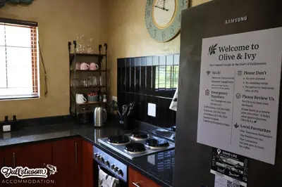 a kitchen with a stove and a sign on the wall at Olive & Ivy Cherry Grove 7 in Dullstroom