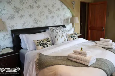 a bedroom with a large bed with towels on it at Olive & Ivy Cherry Grove 7 in Dullstroom