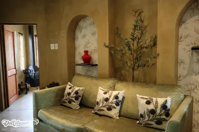 a living room with a green couch with pillows at Olive & Ivy Cherry Grove 7 in Dullstroom