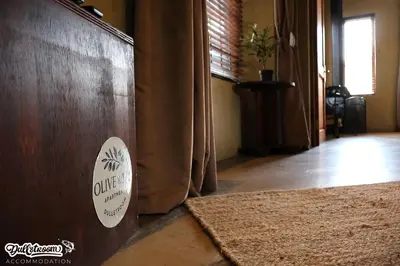 a room with a wooden wall with a sticker on it at Olive & Ivy Cherry Grove 7 in Dullstroom