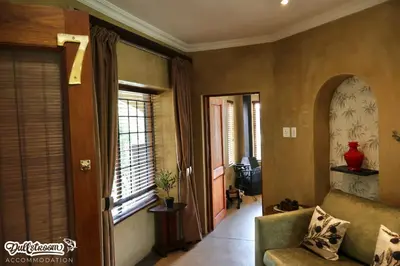 a living room with a couch and a window at Olive & Ivy Cherry Grove 7 in Dullstroom