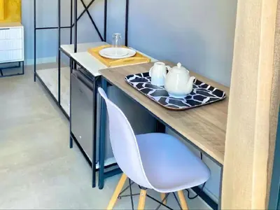 a kitchen counter with a table and a chair at MRF Lodge in Louis Trichardt