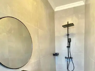 a bathroom with a round mirror on the wall at MRF Lodge in Louis Trichardt