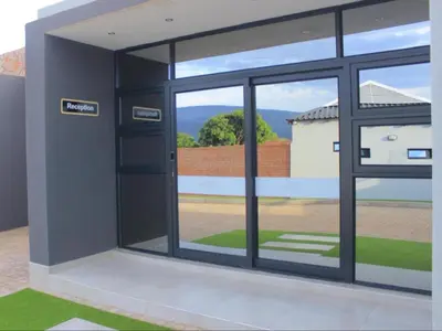 an open glass door with a view of a field at MRF Lodge in Louis Trichardt