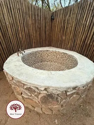 a circular stone fountain in front of a wooden fence at Zebula - Bushveld Waters - 20 Pax in Warmbaths