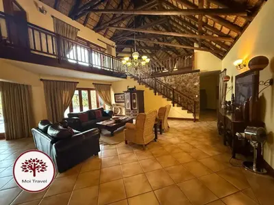 a living room with a couch and chairs and a staircase at Zebula - Bushveld Waters - 20 Pax in Warmbaths