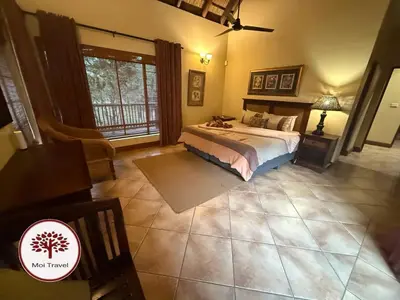 a bedroom with a bed and a large window at Zebula - Bushveld Waters - 20 Pax in Warmbaths