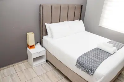 a small bedroom with a bed and a box on a night stand at Grace View Guest House in Chartwell