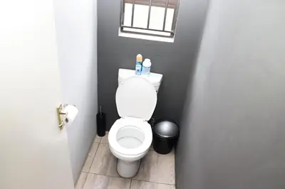a small bathroom with a toilet and a window at Grace View Guest House in Chartwell