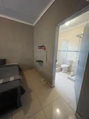 a bathroom with a door open to a bathroom with a toilet at Mbombela Stay in Nelspruit