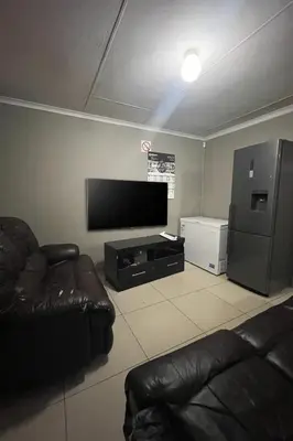 a living room with a couch and a flat screen tv at Mbombela Stay in Nelspruit