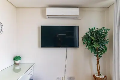 a flat screen tv on a wall with a plant at Ellipse Waterfall - Luxe Urban Escape in Midrand