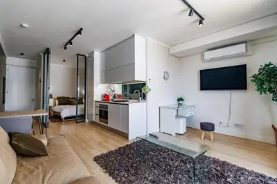 a living room with a couch and a tv in a room at Ellipse Waterfall - Luxe Urban Escape in Midrand