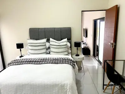 a bedroom with a large bed with white sheets and pillows at The Hill in Boschrand