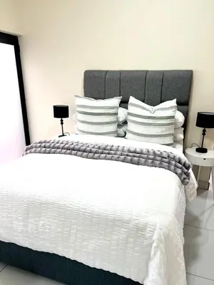 a bedroom with a large bed with white sheets and pillows at The Hill in Boschrand