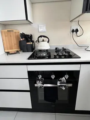 a kitchen with a stove with a tea kettle on it at The Hill in Boschrand