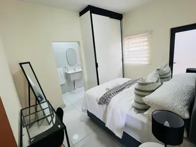 a bedroom with a bed and a mirror at The Hill in Boschrand