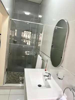 a bathroom with a sink and a shower with a mirror at The Hill in Boschrand