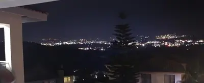 a view of a city at night with a tree at The Hill in Boschrand