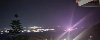 a view of a city at night with lights at The Hill in Boschrand