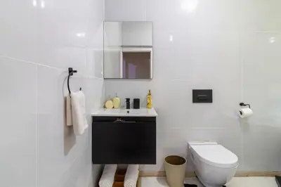 a white bathroom with a toilet and a sink at City Retreat Safari Sunninghill in Sandton