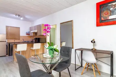 a dining room with a glass table and chairs at City Retreat Safari Sunninghill in Sandton
