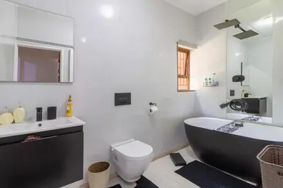 a bathroom with a tub and a toilet and a sink at City Retreat Safari Sunninghill in Sandton