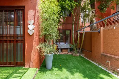 a garden with a teddy bear on the side of a building at City Retreat Safari Sunninghill in Sandton