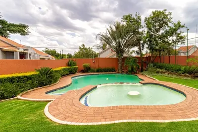 a small swimming pool in a yard with a brick fence at City Retreat Safari Sunninghill in Sandton