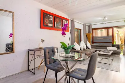 a living room with a glass table and a couch at City Retreat Safari Sunninghill in Sandton