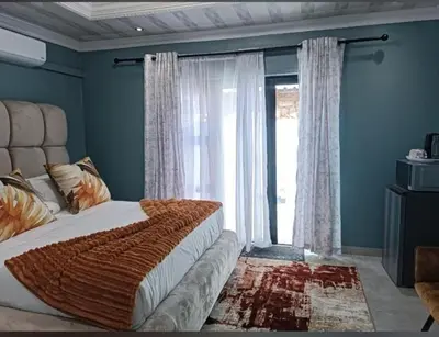 a bedroom with a bed and a large window at De Rams boutique guest house