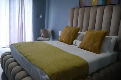 a bedroom with a large bed with yellow pillows at De Rams boutique guest house