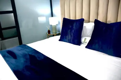 a bedroom with a large bed with blue pillows at De Rams boutique guest house