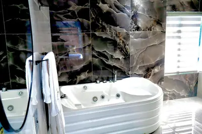 a bathroom with a white tub and a sink at De Rams boutique guest house