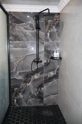 a shower with a stone wall in a bathroom at De Rams boutique guest house