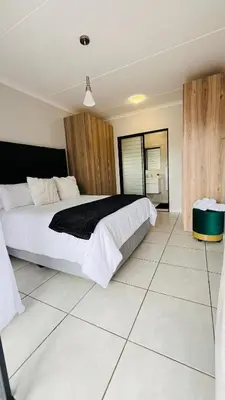 a bedroom with a large bed and a tiled floor at The Legacy at The Blyde in Pretoria