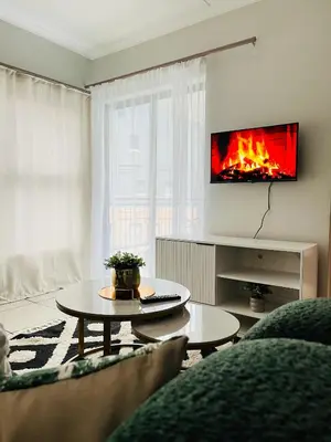 a living room with a table and a fireplace at The Legacy at The Blyde in Pretoria
