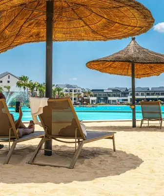two people laying in chairs on the beach with umbrellas at The Legacy at The Blyde in Pretoria