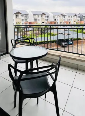 a table and a chair sitting on a balcony with a view at The Legacy at The Blyde in Pretoria