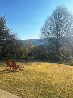 two wooden benches sitting in a field of grass at Walkerson Estate Country Home in Dullstroom